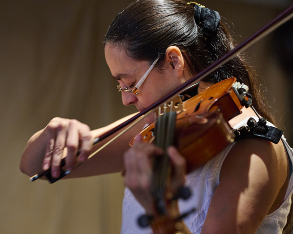 a person playing a violin with focus in a dynamic pose showcasing skill and movement in music performance 2 instruments melody harmonious